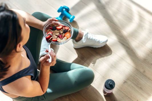 Athletic woman refueling with a protein- and fiber-rich cereal and berries after a workout, reinforcing the connection between nutrition, recovery, and performance