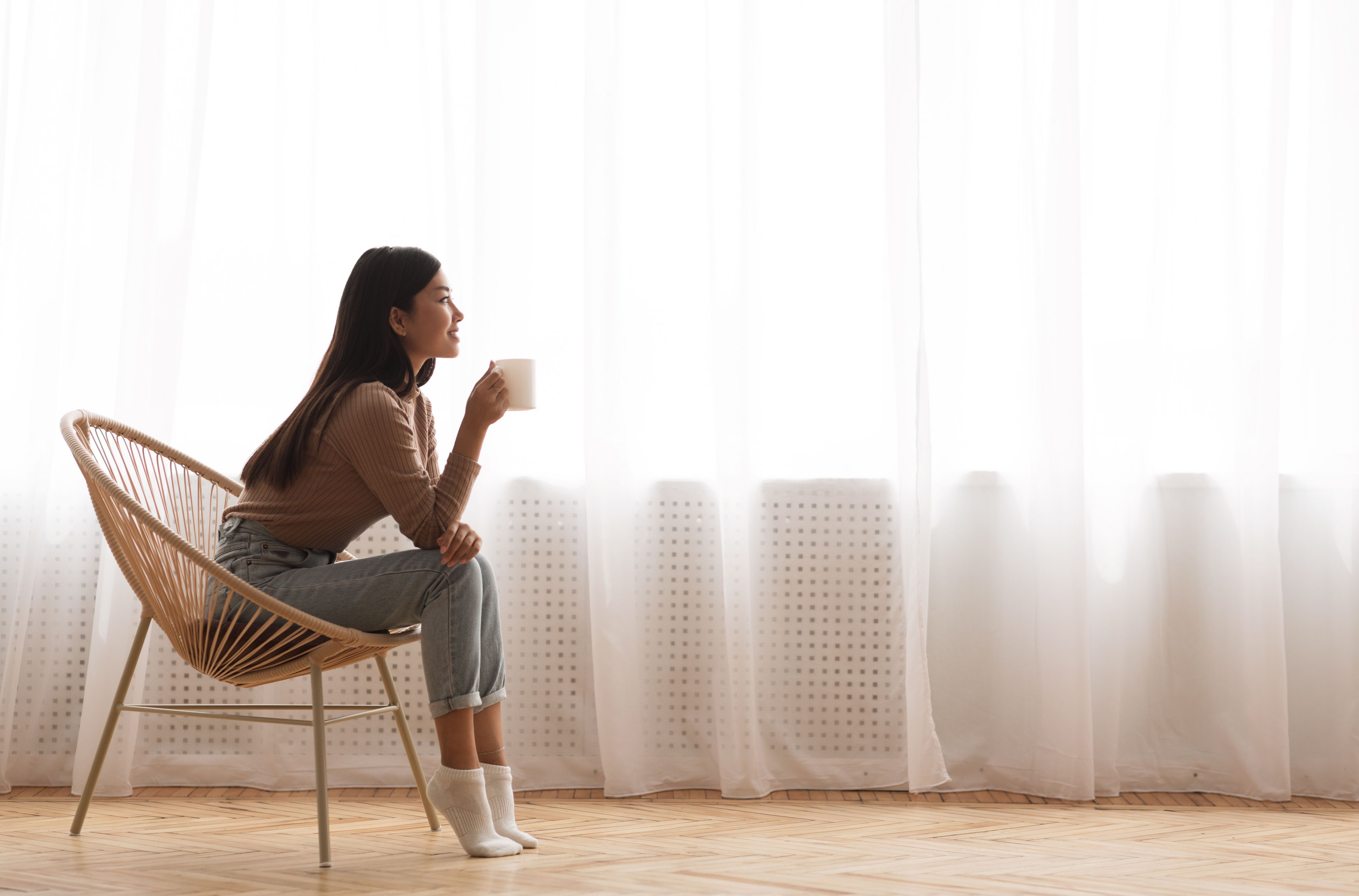 woman starting her morning with calm focus, sipping coffee in natural light—a daily wellness ritual aligned with Imprüv’s philosophy