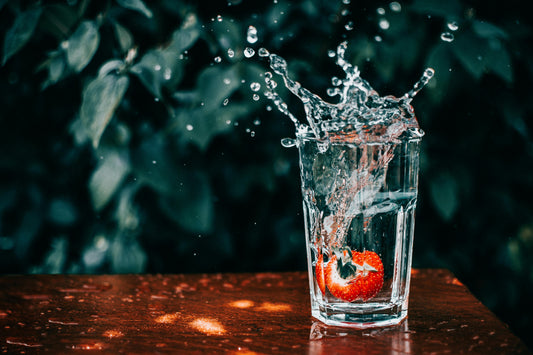 Strawberry splashing into a glass of water captures the moment hydration becomes effective when electrolytes are present not just water