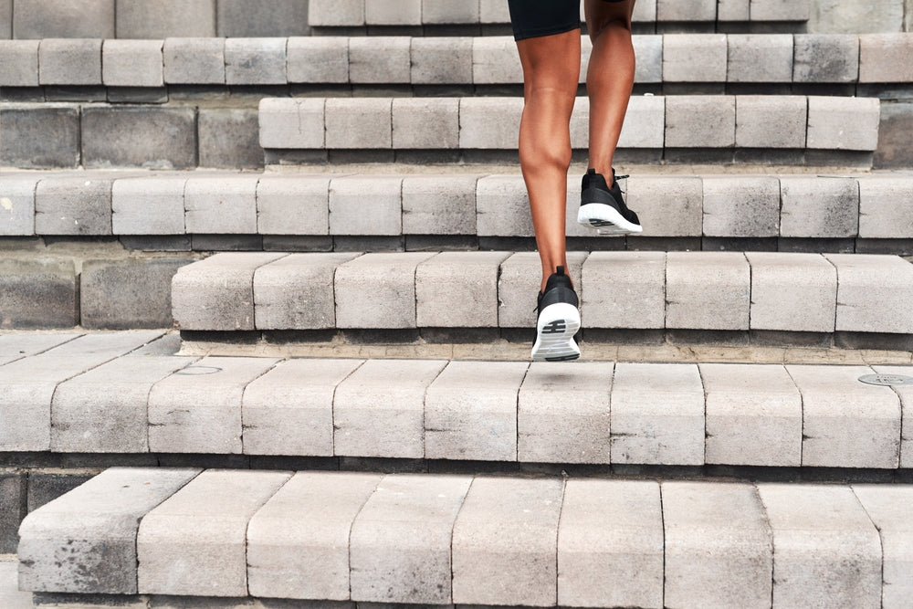 **Optimized Alt Text:** Man climbing outdoor stairs to raise heart rate into aerobic zone, showing how cardio effort is relative to fitness level – Imprüv