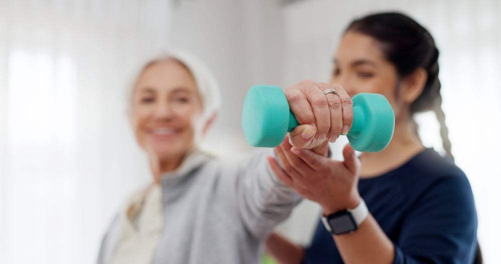 Rehab professional assisting patient with weighted shoulder abduction exercise as part of personalized therapeutic program to restore function and reduce pain.