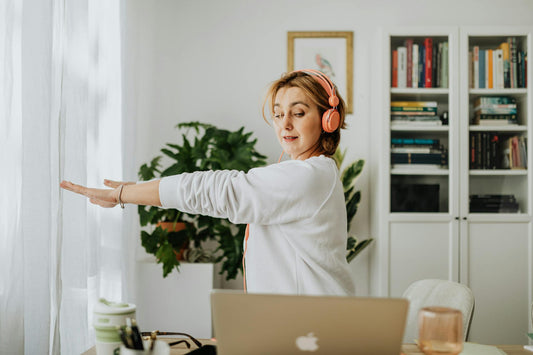 Woman doing mobility exercises at her desk to restore joint function and offset the damage of prolonged sitting.
