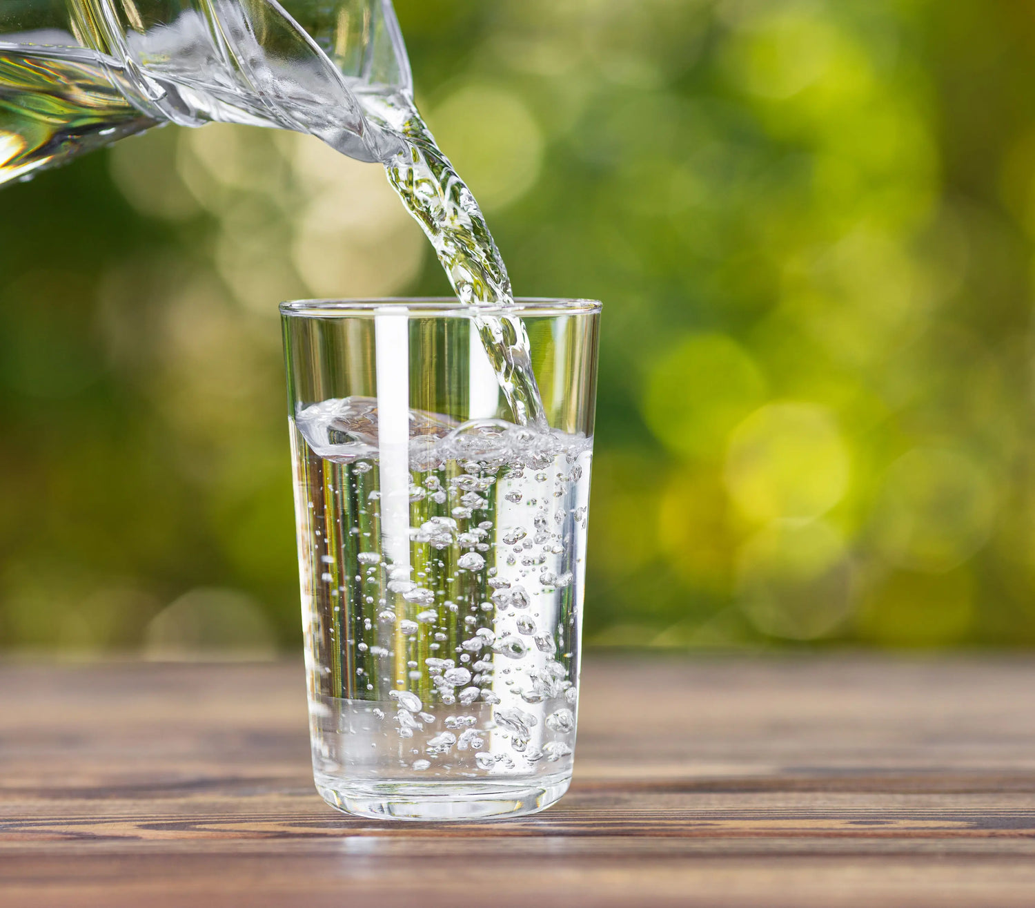 Glass pitcher of water pouring into a glass cup - imprüv 