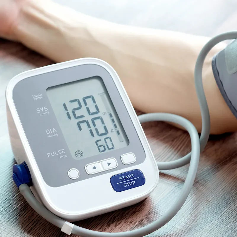 Upper arm blood pressure monitor displaying a healthy reading during home health monitoring